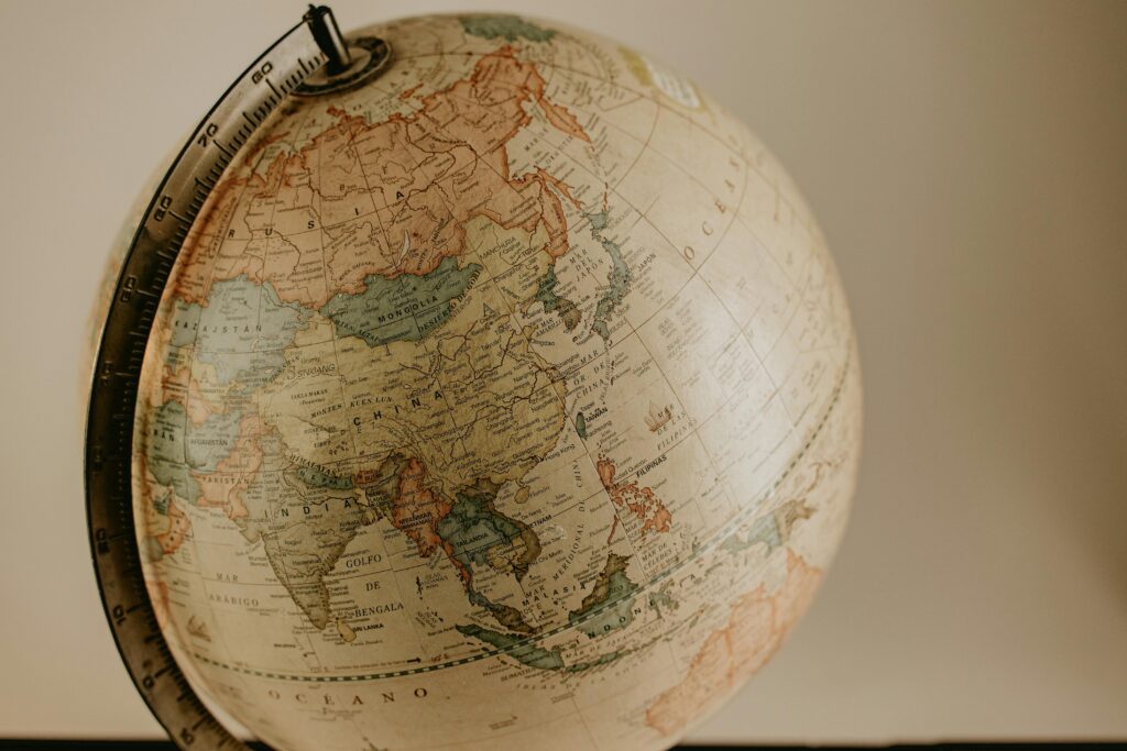 A vintage globe displaying the continents of Asia and Europe in sepia tones, ideal for travel concepts.